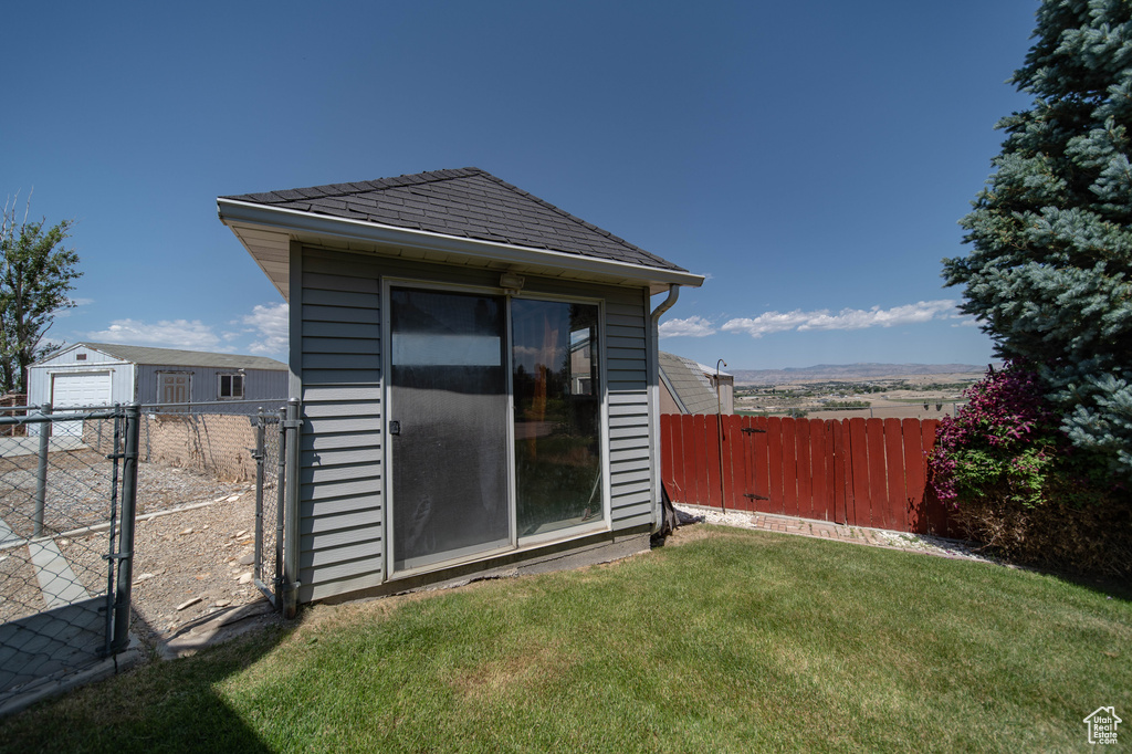 Back of house with an outbuilding and a gate