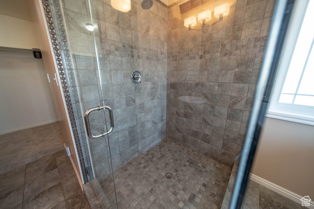 Bathroom with a shower stall and baseboards