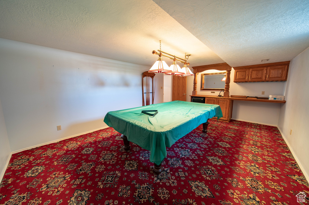 Rec room with carpet floors, a textured ceiling, and pool table