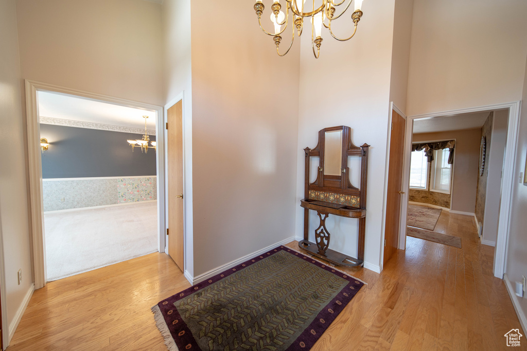 Foyer entrance with a chandelier, a high ceiling, and wood finished floors