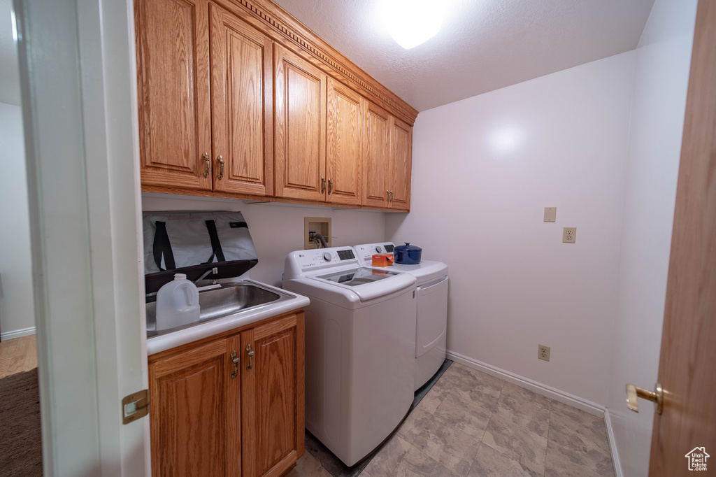 Washroom featuring washing machine and clothes dryer and cabinet space