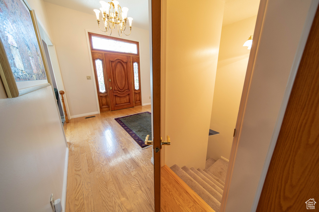 Entryway featuring a chandelier, wood finished floors, and stairs