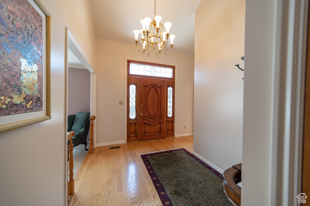 Foyer entrance featuring a chandelier and light wood finished floors