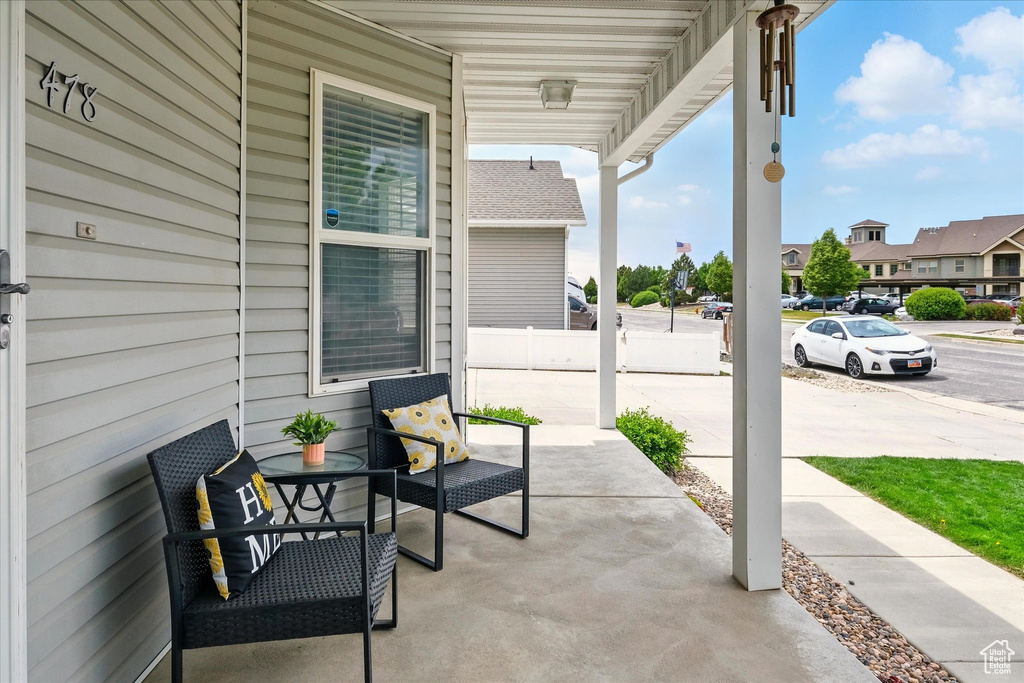 Covered porch featuring a residential view