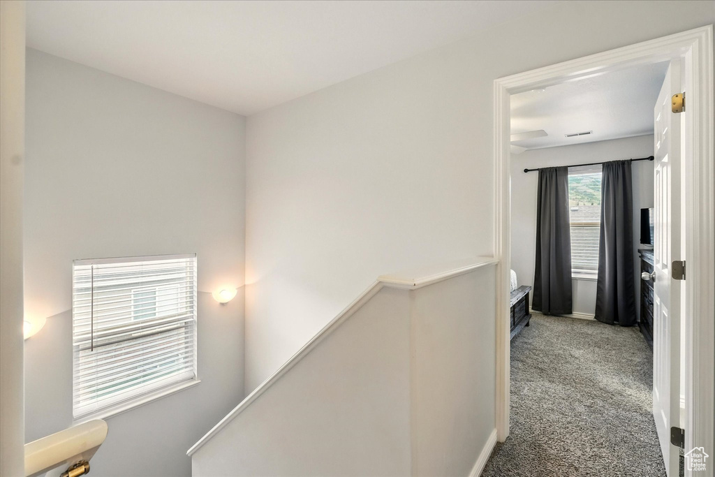 Hallway with an upstairs landing and carpet