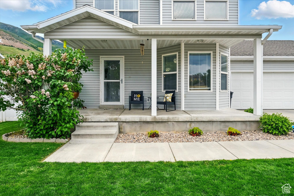 Entrance to property featuring a porch, a garage, and a mountain view