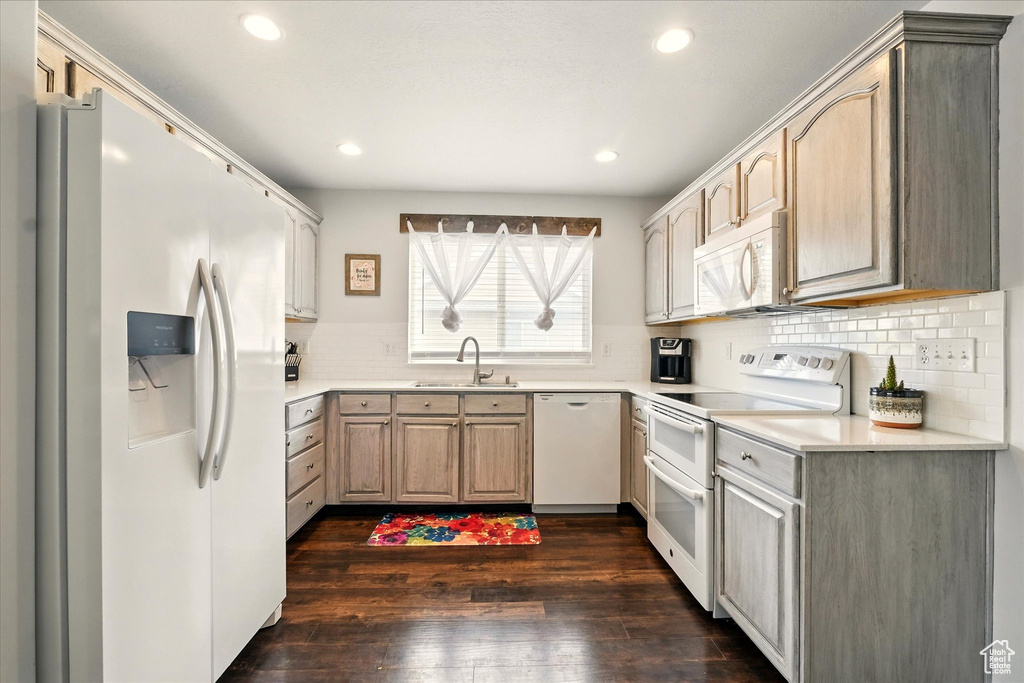 Kitchen featuring white appliances, dark wood-style floors, tasteful backsplash, light countertops, and recessed lighting