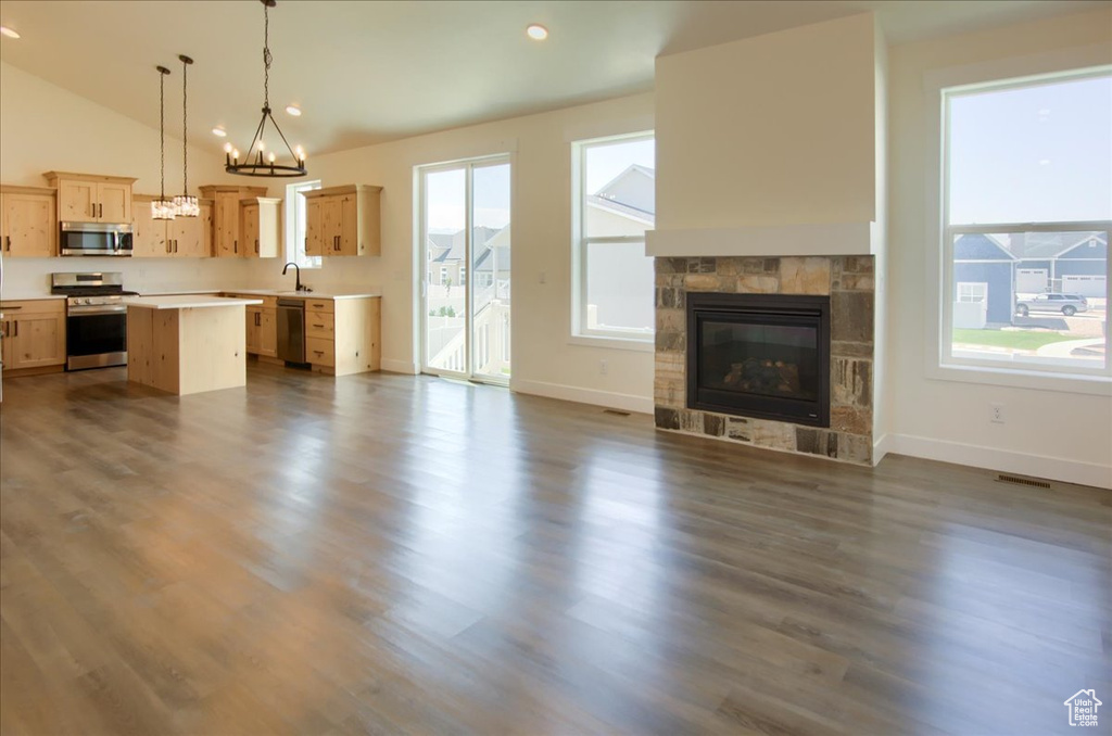 Kitchen with appliances with stainless steel finishes, open floor plan, light brown cabinetry, light countertops, and plenty of natural light