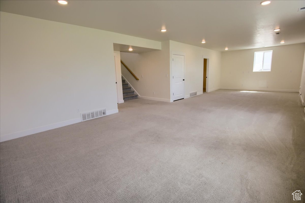 Below grade area featuring stairway, light colored carpet, and recessed lighting