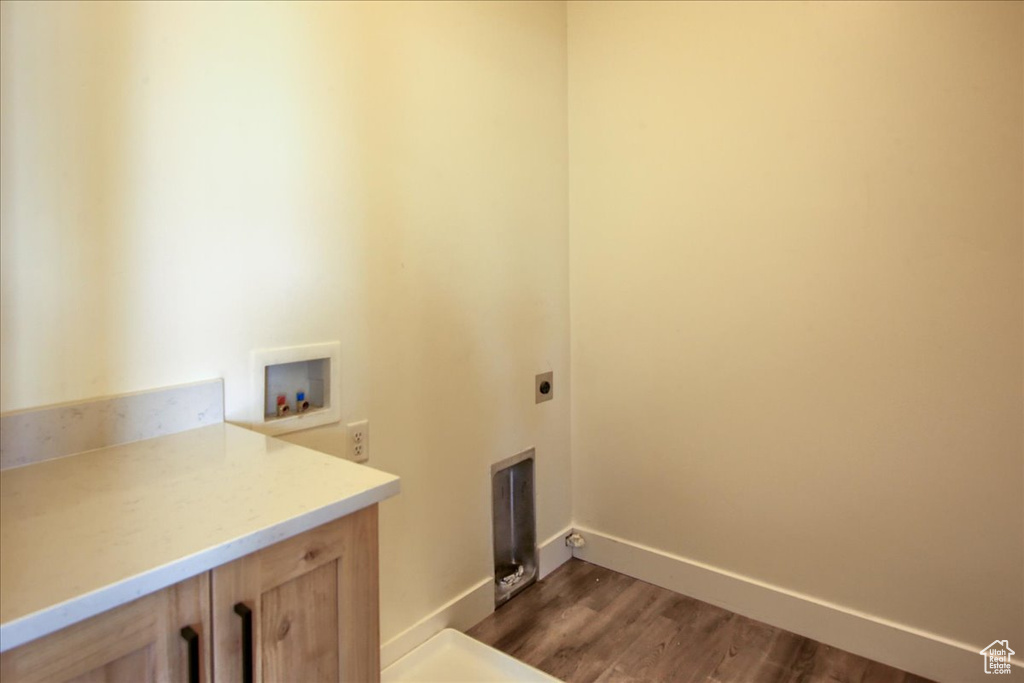 Laundry area featuring hookup for an electric dryer, washer hookup, dark wood-style floors, and cabinet space