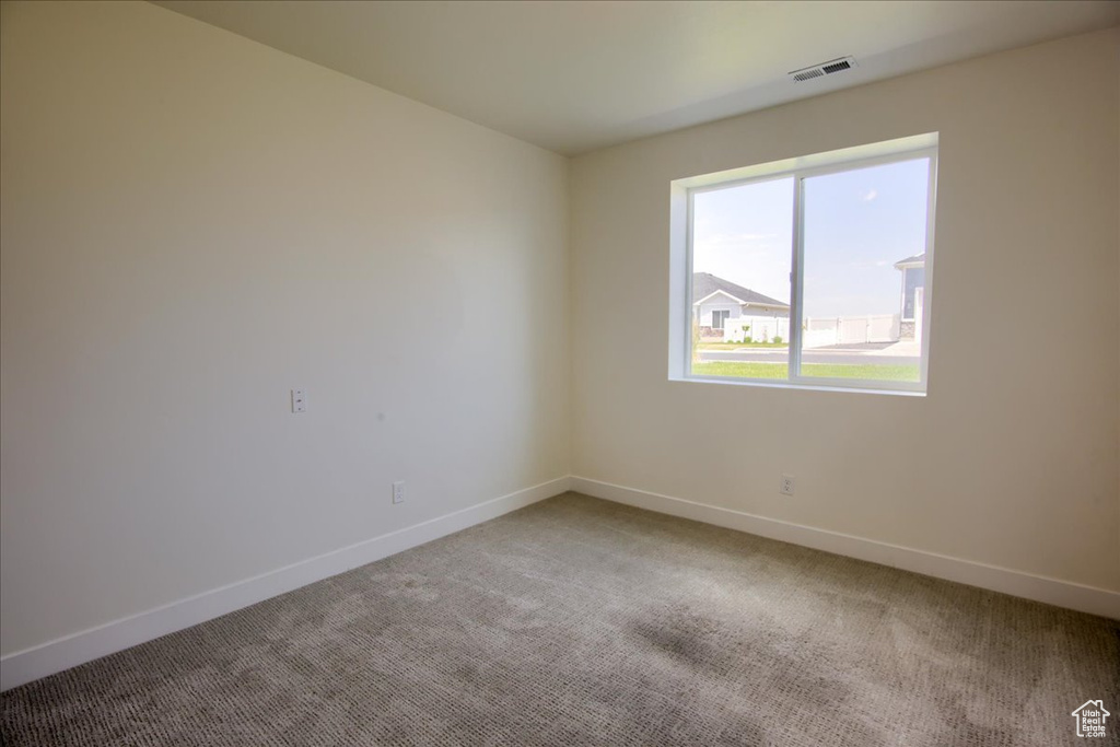 Spare room with light carpet and baseboards