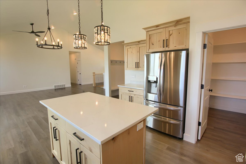 Kitchen featuring stainless steel fridge, a chandelier, dark wood-style flooring, and a center island