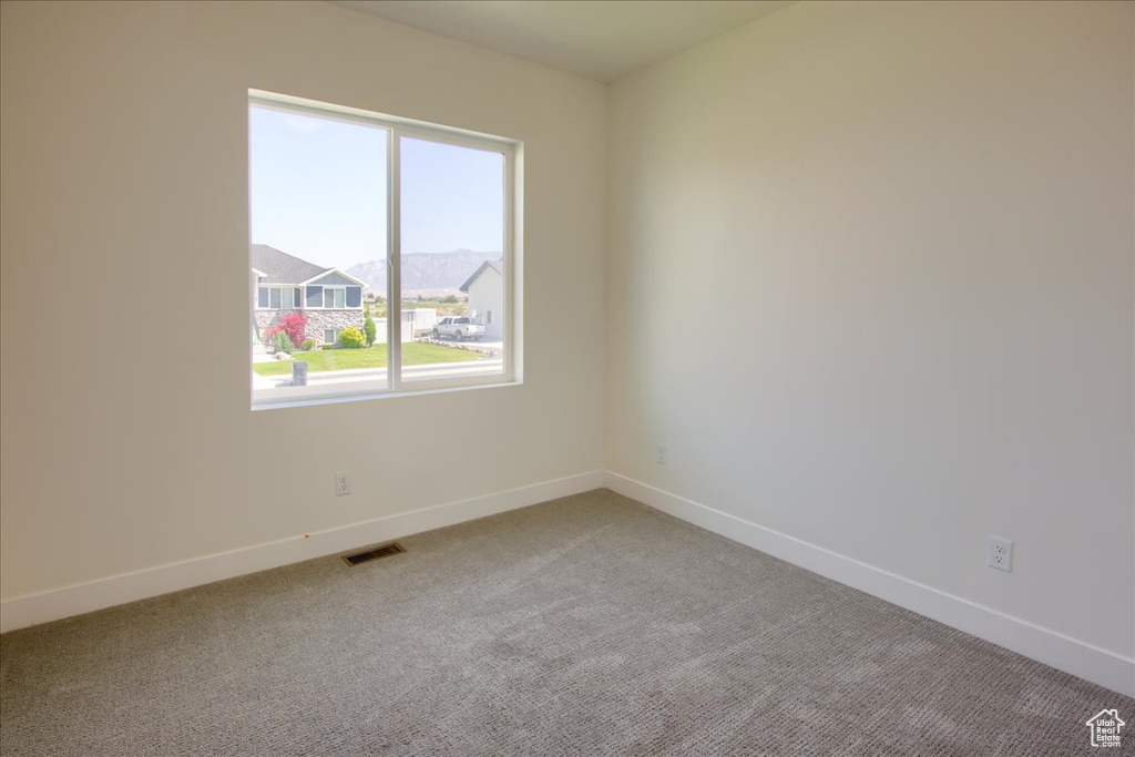 Spare room featuring light colored carpet and baseboards