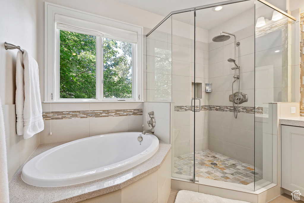 Full bathroom with a bath, a stall shower, and vanity