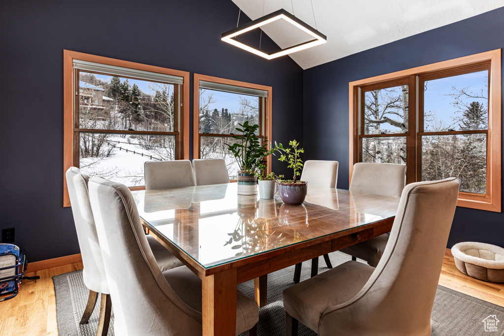 Dining room with wood finished floors and vaulted ceiling