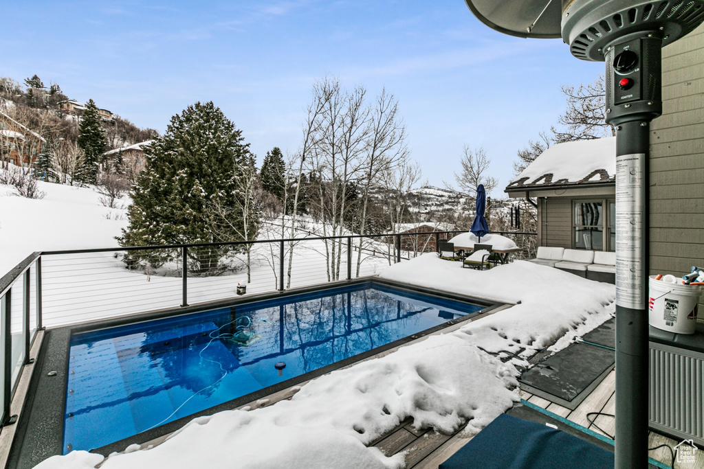 Snow covered pool with a fenced backyard