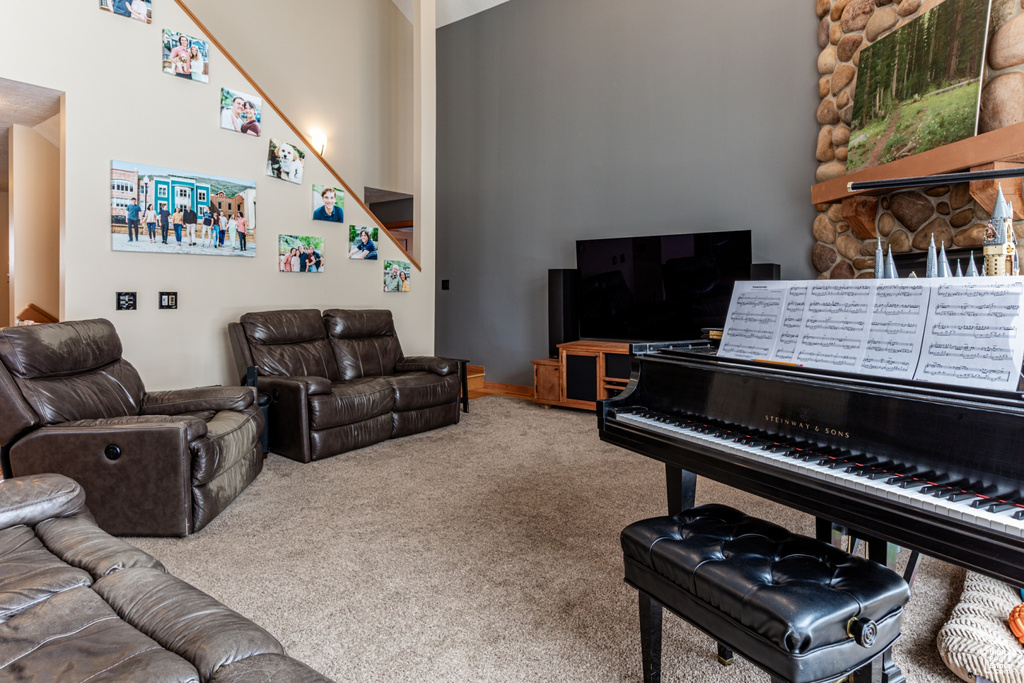 Carpeted living room with a towering ceiling