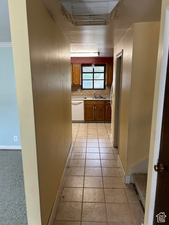 Hall with a sink and light tile patterned floors