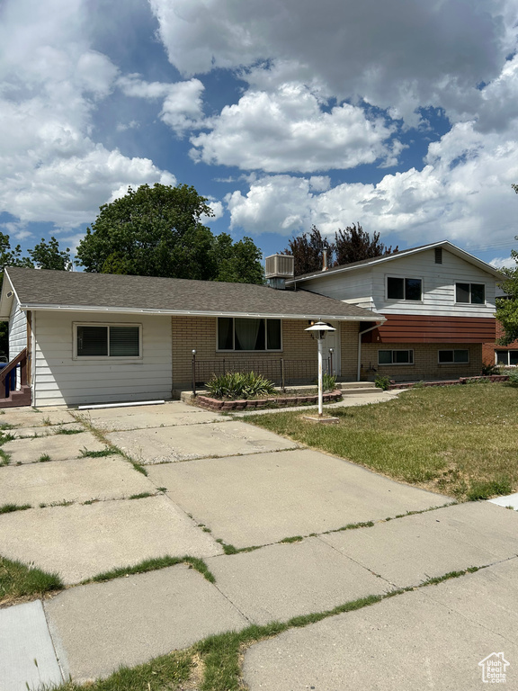 Split level home featuring a front lawn and concrete driveway