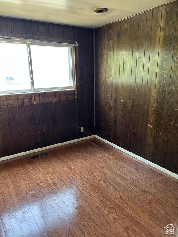 Empty room featuring wood finished floors and wood walls
