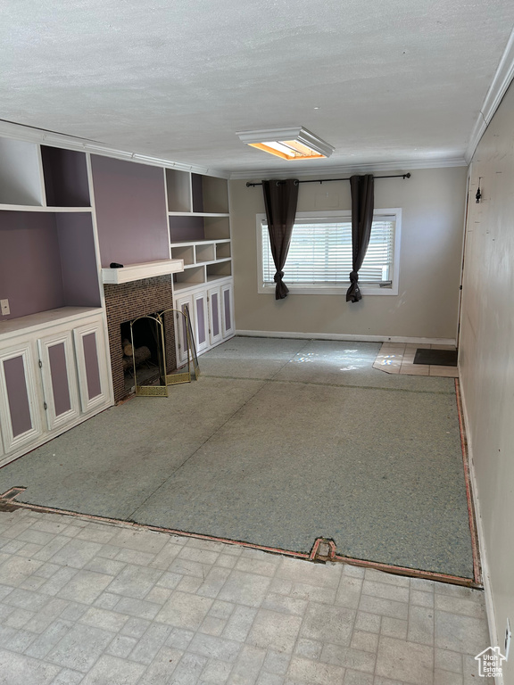 Unfurnished living room with a fireplace, a textured ceiling, and crown molding