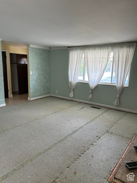 Unfurnished room featuring baseboards and ornamental molding