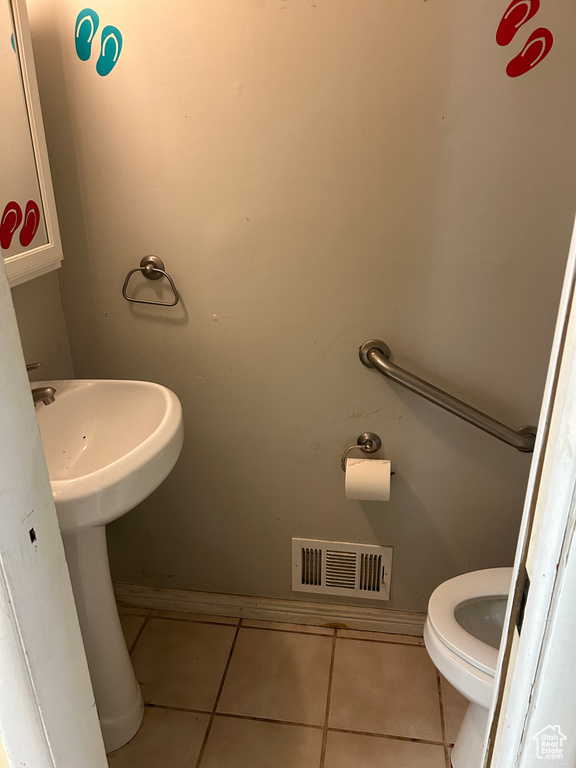 Half bathroom with tile patterned floors and toilet