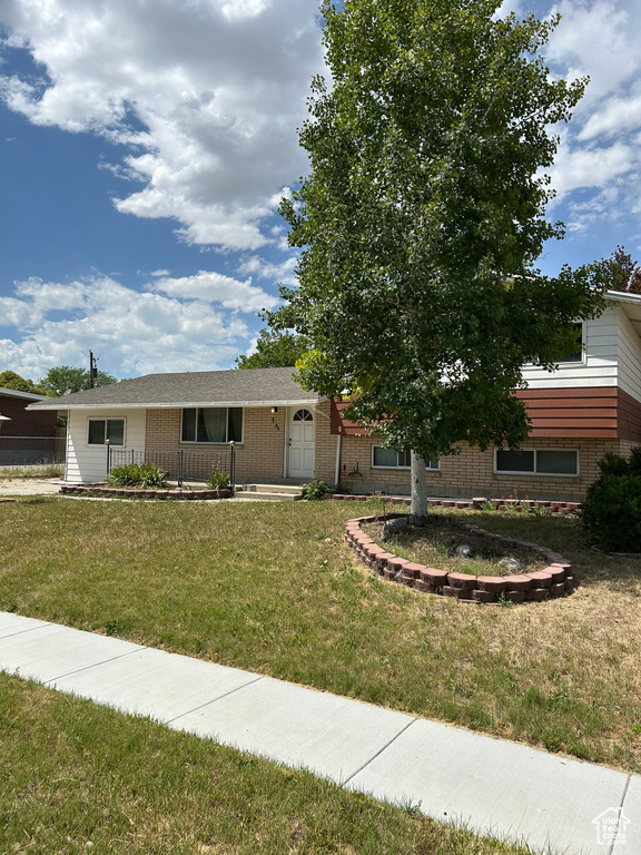 View of front facade with brick siding and a front yard