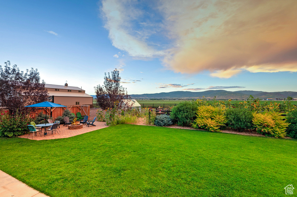 View of yard featuring a patio area, an outdoor fire pit, and a mountain view