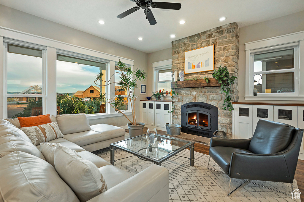 Living area featuring wood finished floors, a ceiling fan, a fireplace, and recessed lighting