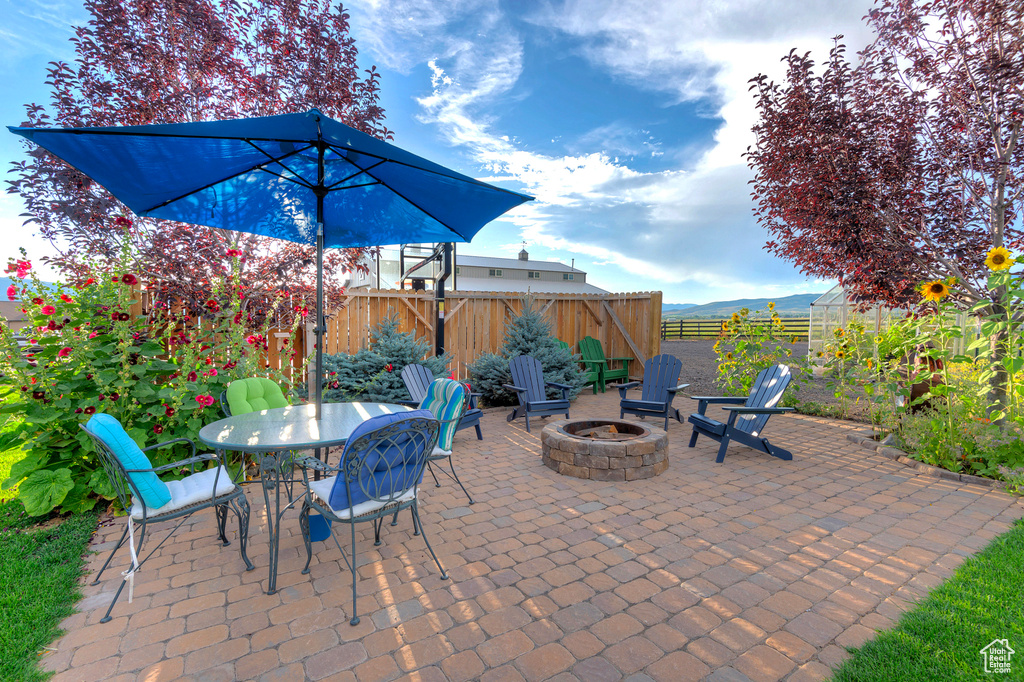 Fenced backyard featuring an outdoor fire pit, a patio, and outdoor dining space