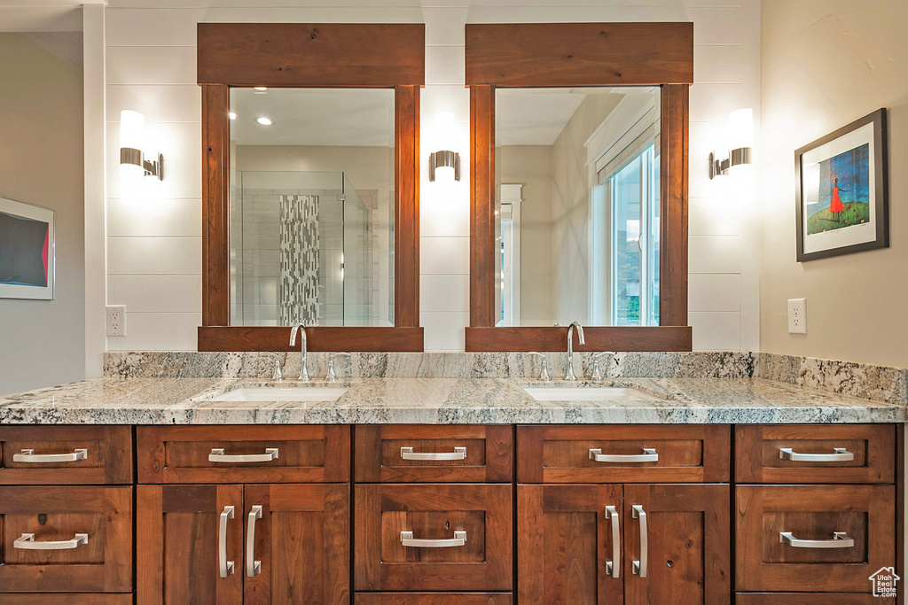 Full bathroom featuring double vanity and a shower stall