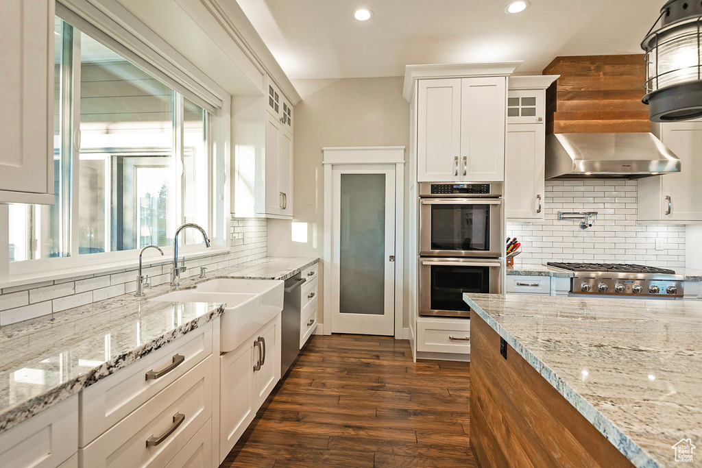 Kitchen with a sink, appliances with stainless steel finishes, glass insert cabinets, recessed lighting, and tasteful backsplash