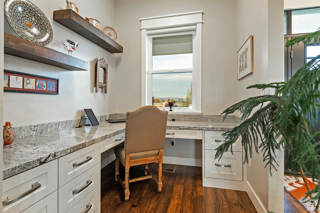 Office with built in study area and dark wood-style flooring