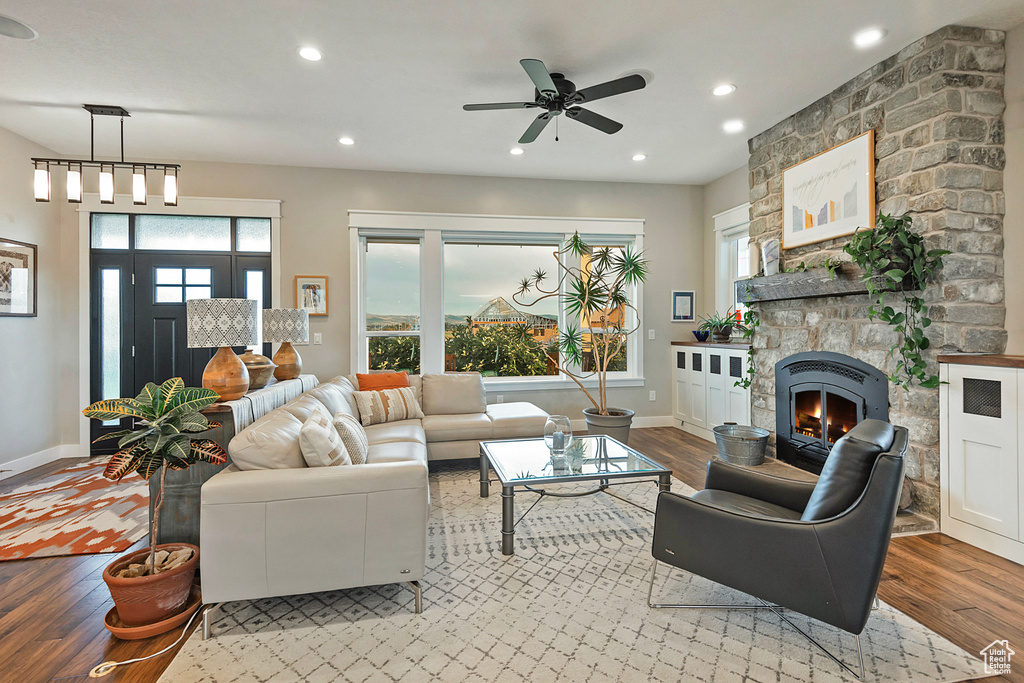 Living room featuring light wood-style flooring, a fireplace, recessed lighting, baseboards, and a ceiling fan