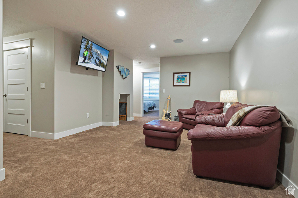 Living area featuring carpet flooring, recessed lighting, baseboards, and a fireplace