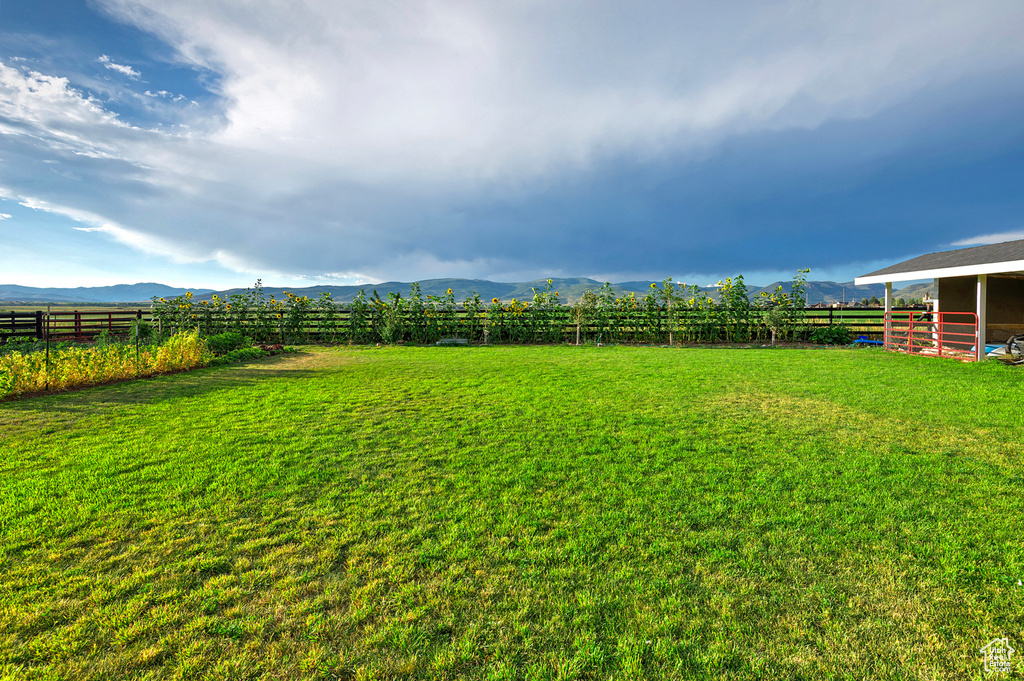 Fenced backyard with a mountain view and a rural view