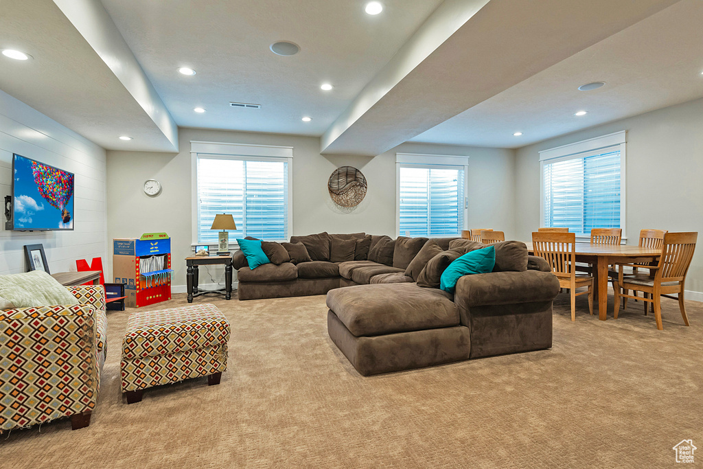 Carpeted living area with recessed lighting, healthy amount of natural light, and baseboards