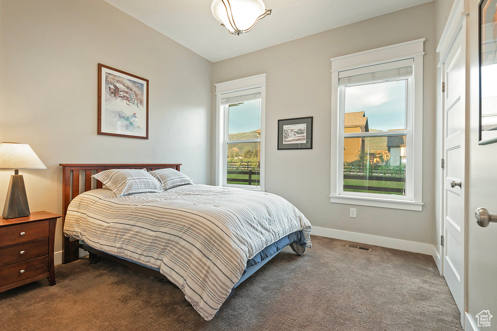 Bedroom with baseboards and dark carpet