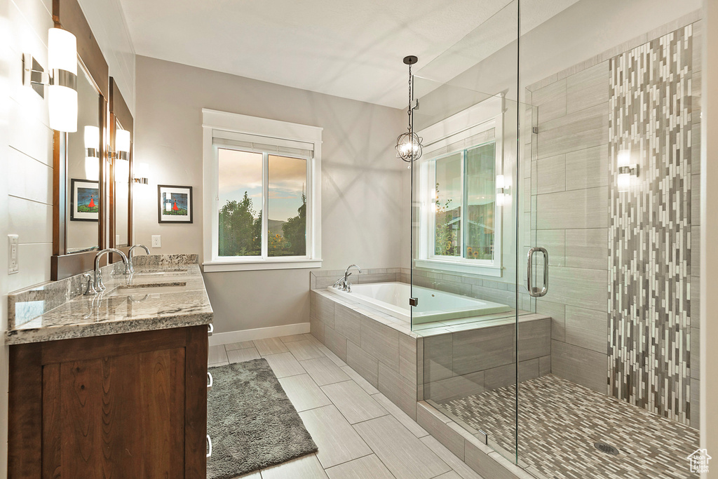 Bathroom featuring plenty of natural light, double vanity, a garden tub, and a shower stall