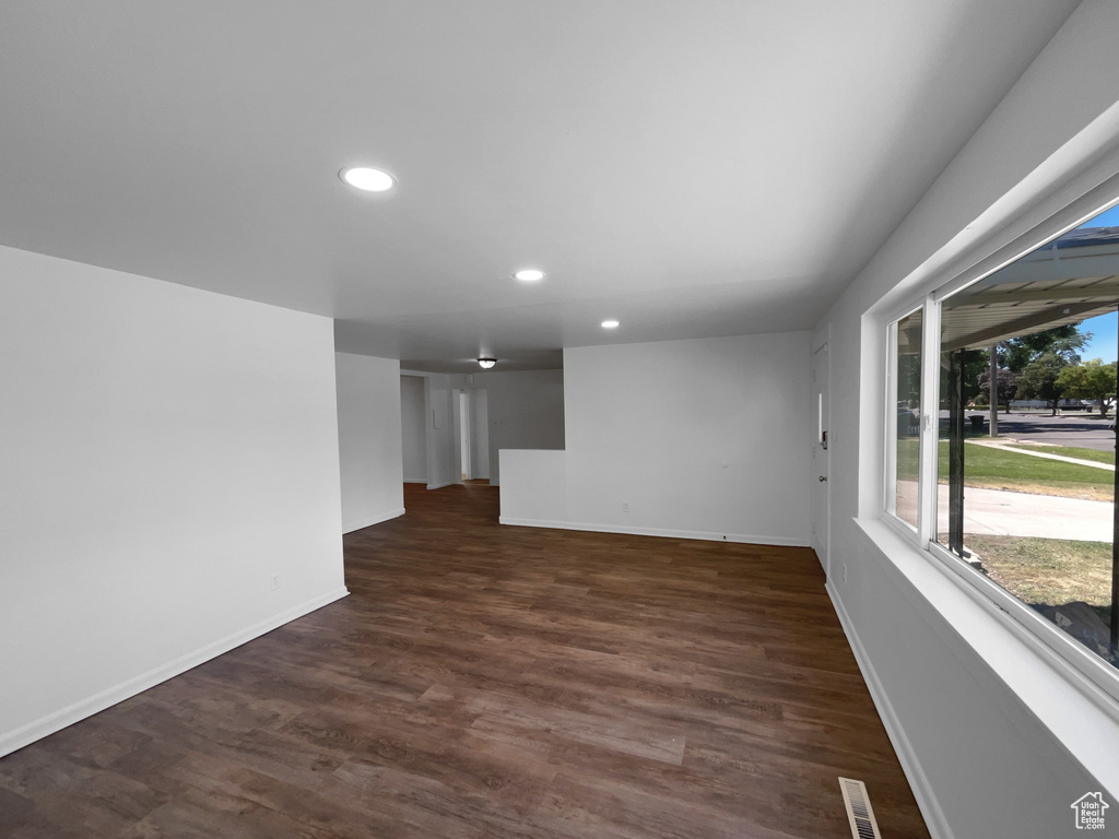 Empty room featuring recessed lighting and dark wood-type flooring
