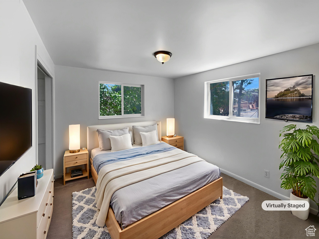 Bedroom featuring dark colored carpet and baseboards