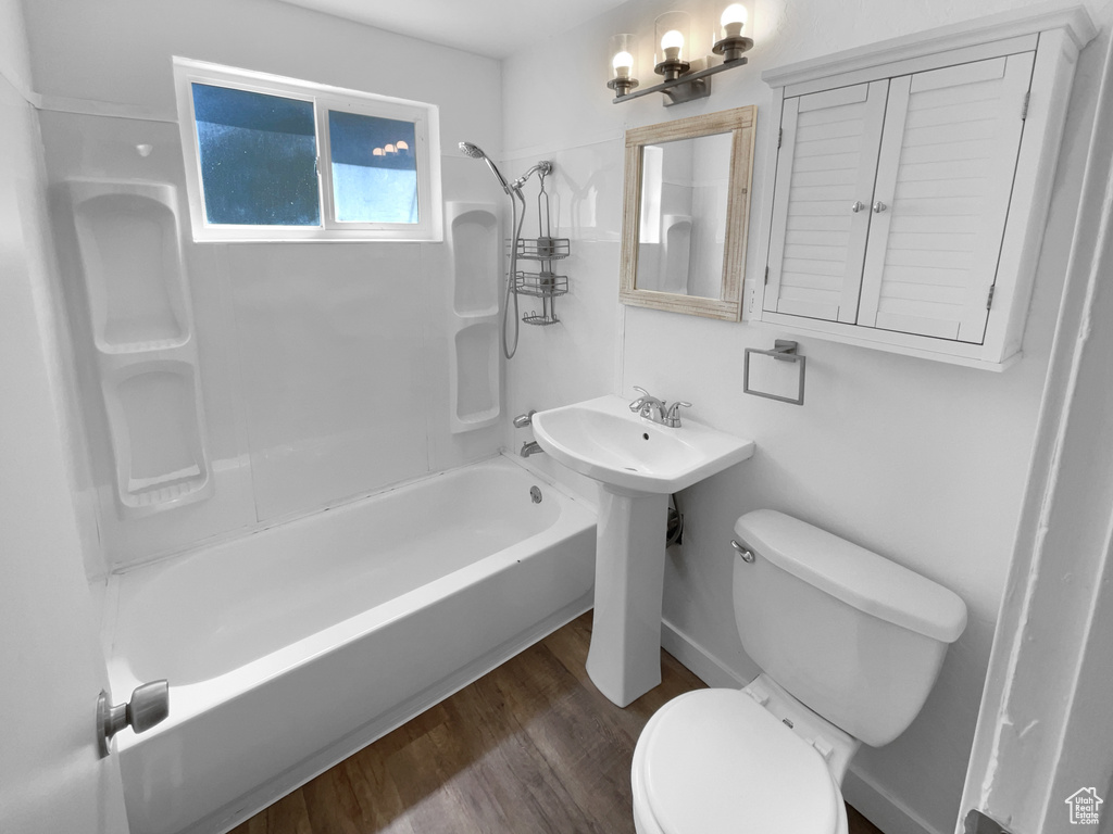Bathroom with shower / washtub combination and wood finished floors