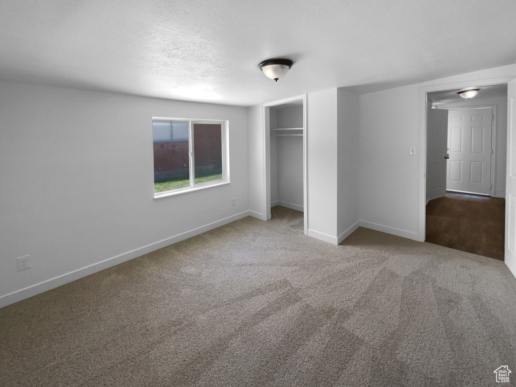 Unfurnished bedroom with carpet floors, a closet, and a textured ceiling