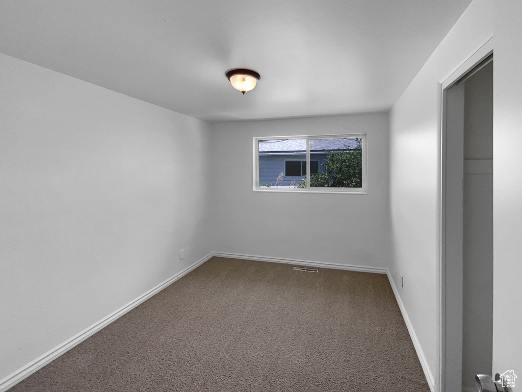 Carpeted empty room featuring baseboards
