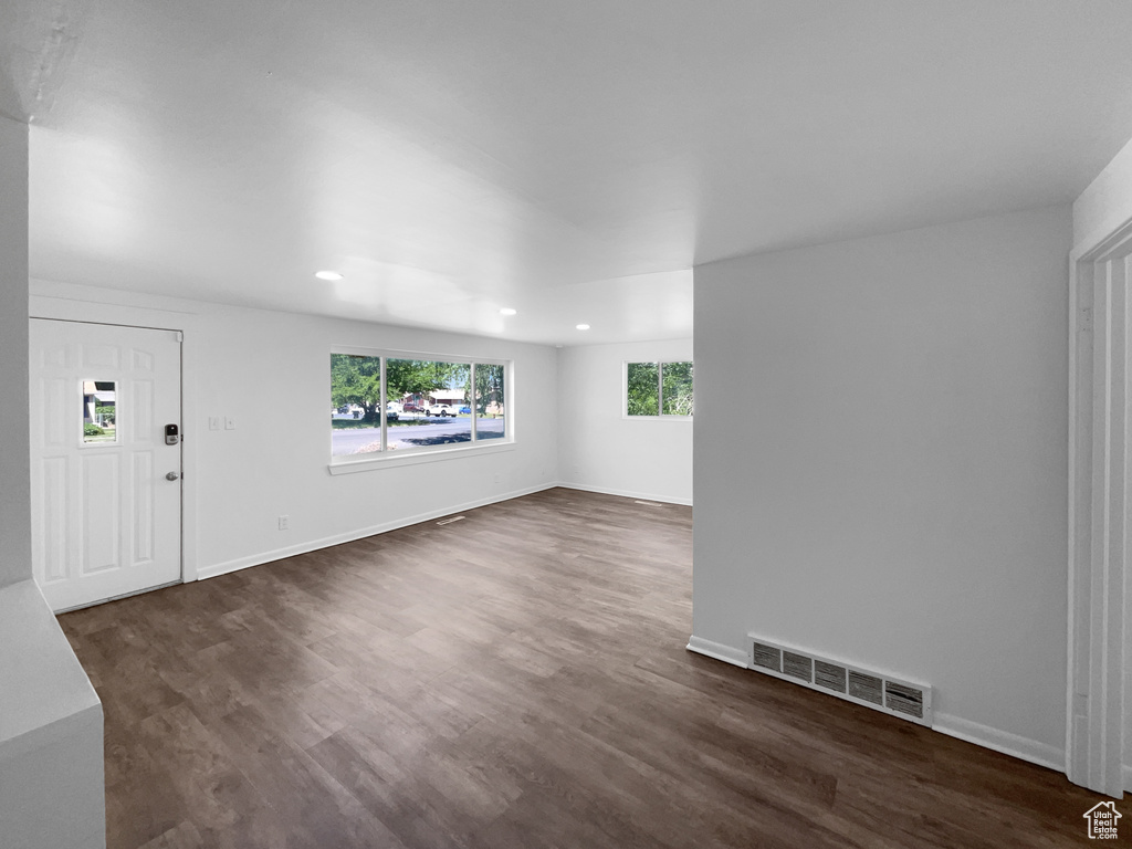 Unfurnished living room featuring dark wood-style floors and recessed lighting