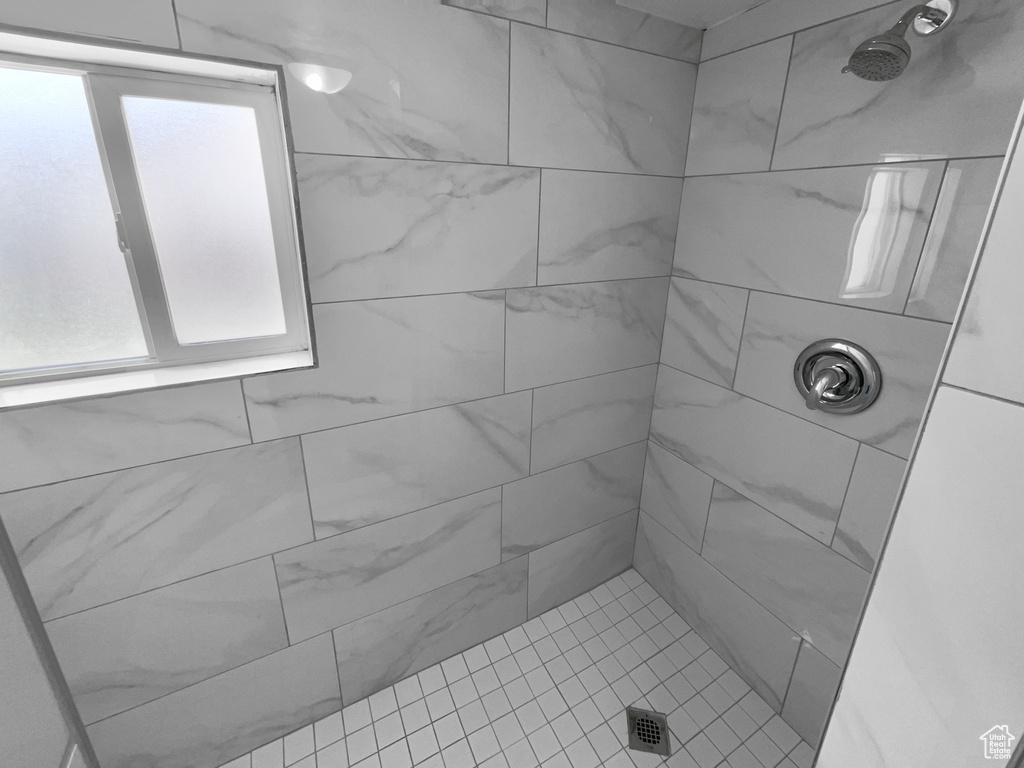 Full bathroom featuring tiled shower and plenty of natural light