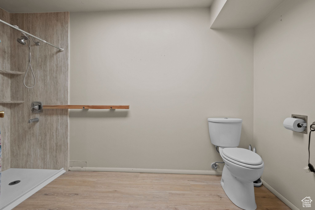 Full bath with a shower and wood finished floors