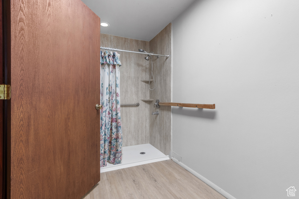 Full bath with a shower stall, wood finished floors, and recessed lighting