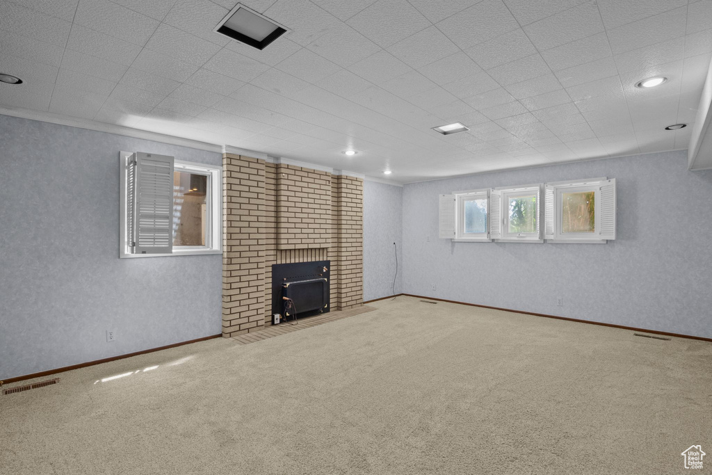 Unfurnished living room with carpet flooring, a wood stove, and recessed lighting